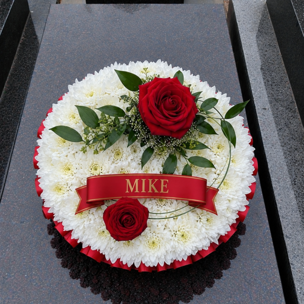 White Base Posy Pad funeral flower arrangement with white blooms and red roses